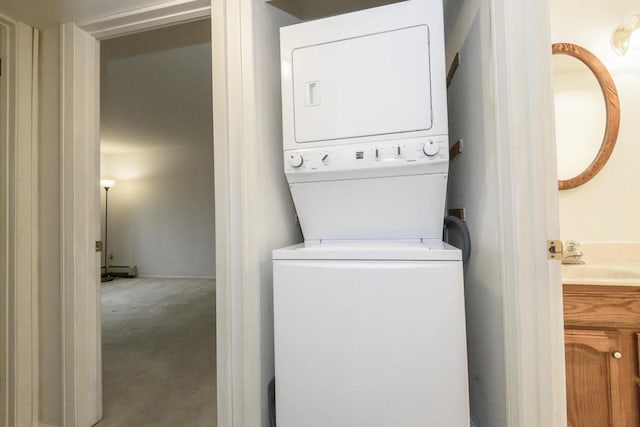 laundry room with a sink, carpet, stacked washer / dryer, and laundry area