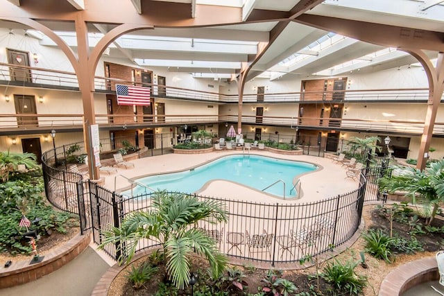 community pool with a patio and fence