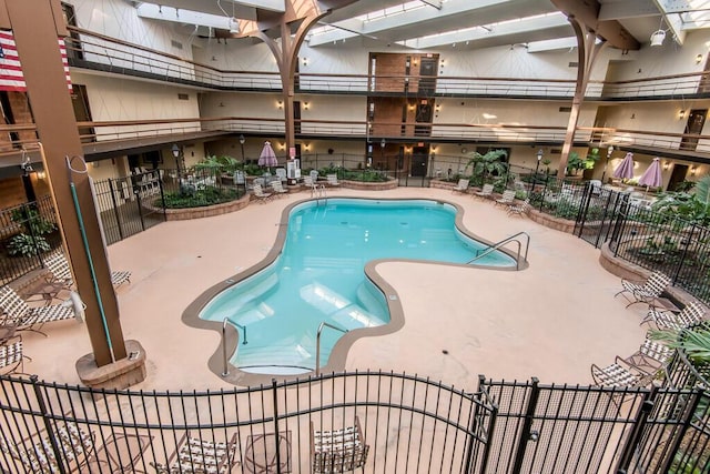 community pool with fence and a patio area