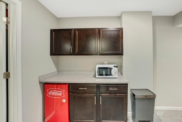 bar with baseboards, carpet, and white microwave