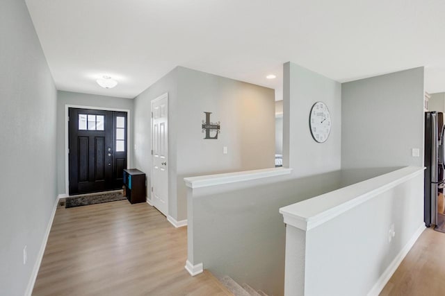 foyer entrance with baseboards and light wood-type flooring
