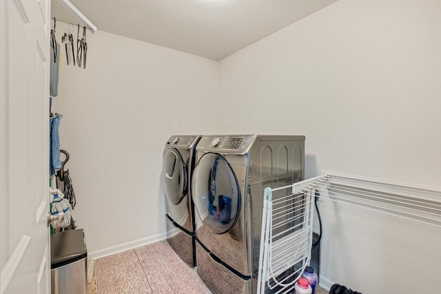 clothes washing area with laundry area, washing machine and dryer, baseboards, and carpet
