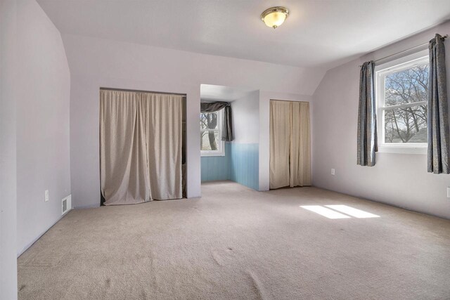 1112 Marquette Ave, Green Bay, WI 54304 - unfurnished bedroom featuring visible vents, carpet floors, and vaulted ceiling