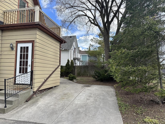 exterior space featuring a patio, fence, and a balcony