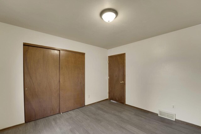 8022 W Glenbrook Rd, Milwaukee, WI 53223 - unfurnished bedroom featuring light wood-style floors, baseboards, a closet, and visible vents