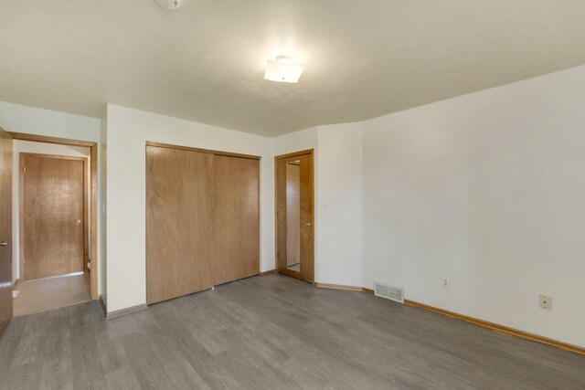 8022 W Glenbrook Rd, Milwaukee, WI 53223 - unfurnished bedroom with baseboards, visible vents, wood finished floors, and a closet
