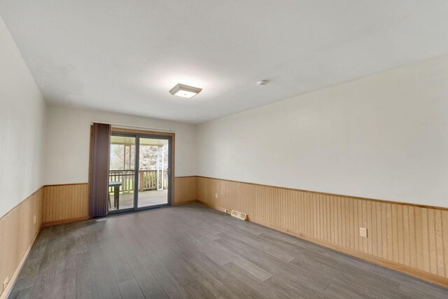 8022 W Glenbrook Rd, Milwaukee, WI 53223 - empty room featuring visible vents, wood walls, wood finished floors, and a wainscoted wall