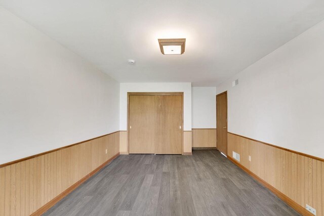 8022 W Glenbrook Rd, Milwaukee, WI 53223 - empty room featuring visible vents, wood finished floors, and a wainscoted wall