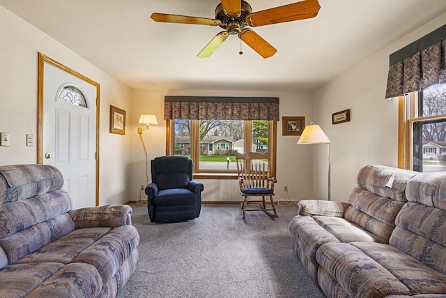 carpeted living room with baseboards and ceiling fan