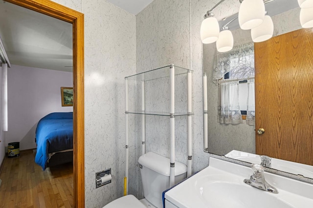 bathroom featuring a sink, wood-type flooring, toilet, and connected bathroom