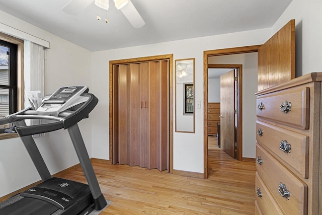workout room featuring baseboards, ceiling fan, and light wood finished floors