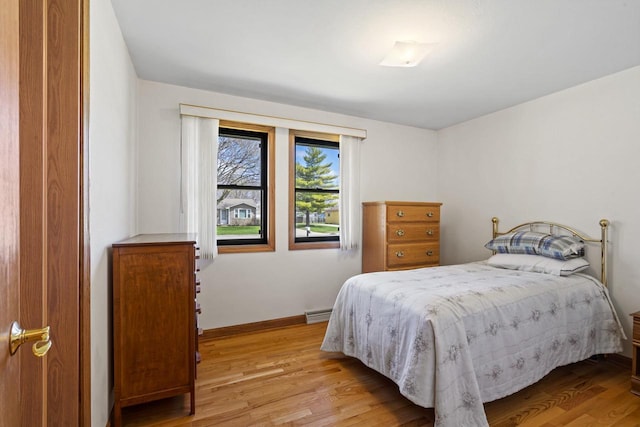 bedroom with light wood-type flooring and baseboards