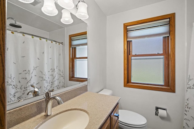 full bath featuring toilet, a shower with shower curtain, and vanity