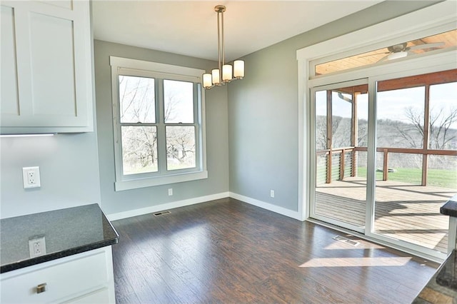 203 Walnut Hill Way, River Falls, WI 54022 - unfurnished dining area with baseboards, healthy amount of natural light, dark wood finished floors, and a chandelier