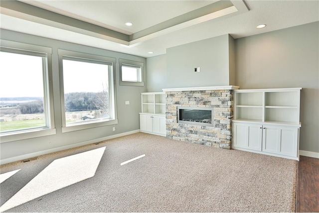 203 Walnut Hill Way, River Falls, WI 54022 - unfurnished living room with baseboards, a fireplace, carpet flooring, recessed lighting, and a raised ceiling