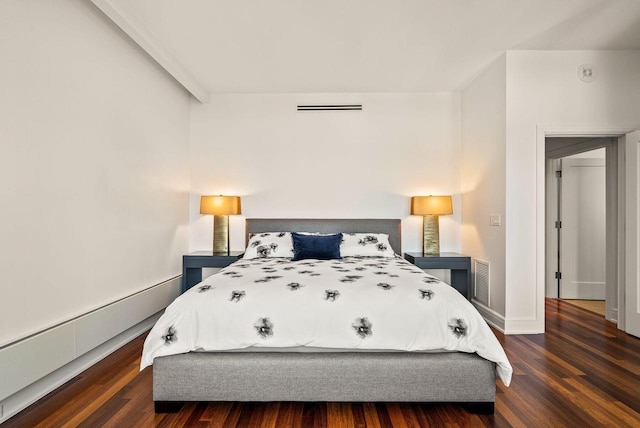 bedroom featuring baseboards, visible vents, and wood finished floors