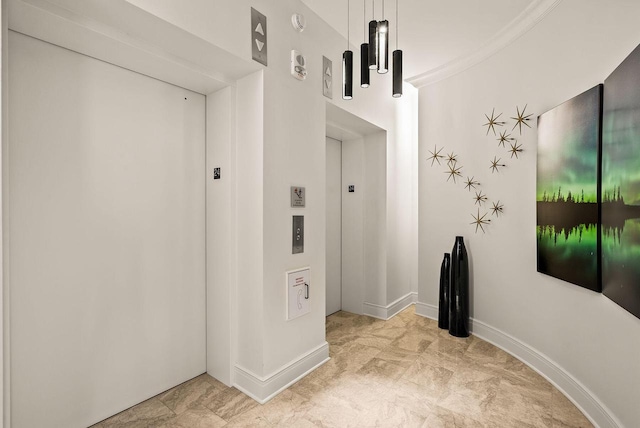 hallway featuring elevator and baseboards