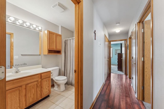 bathroom featuring tile patterned flooring, vanity, toilet, curtained shower, and visible vents