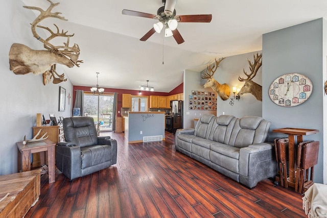 living area featuring visible vents, lofted ceiling, ceiling fan with notable chandelier, and dark wood-type flooring