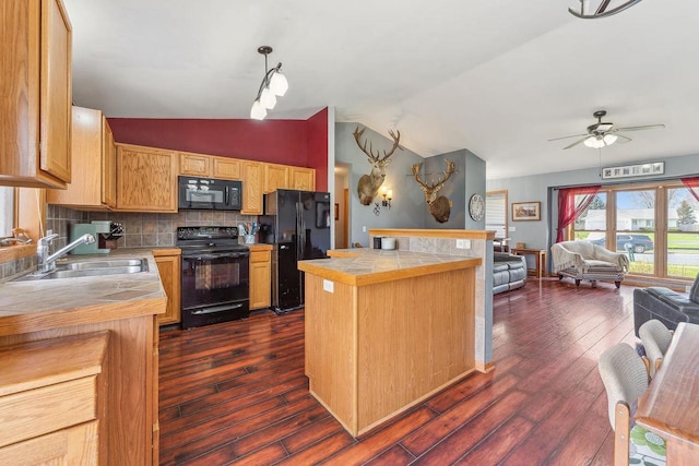 kitchen featuring open floor plan, ceiling fan, tile counters, a sink, and black appliances