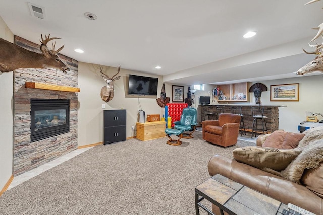 living area with recessed lighting, visible vents, a bar, and a fireplace