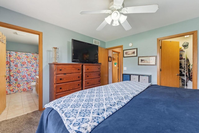bedroom with ceiling fan, tile patterned flooring, carpet, a spacious closet, and visible vents