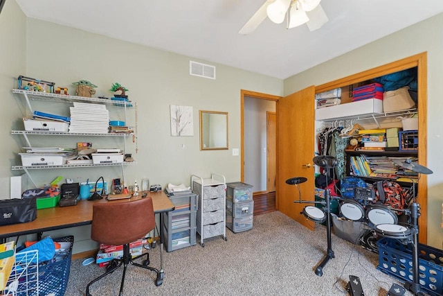 carpeted office with visible vents and ceiling fan