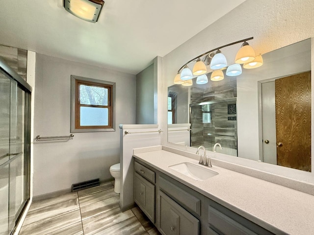 226 Westridge Rd, Janesville, WI 53548 - bathroom with vanity, wood finished floors, toilet, baseboards, and a shower stall