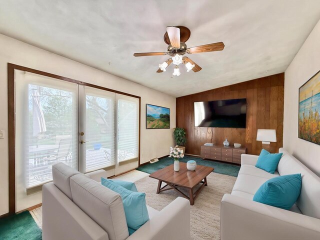 226 Westridge Rd, Janesville, WI 53548 - living room with wood walls, a ceiling fan, and carpet flooring