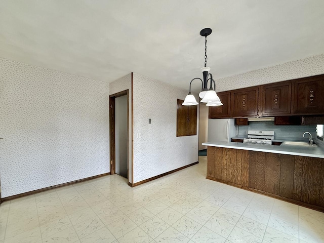 226 Westridge Rd, Janesville, WI 53548 - kitchen featuring a peninsula, white appliances, wallpapered walls, light countertops, and a sink