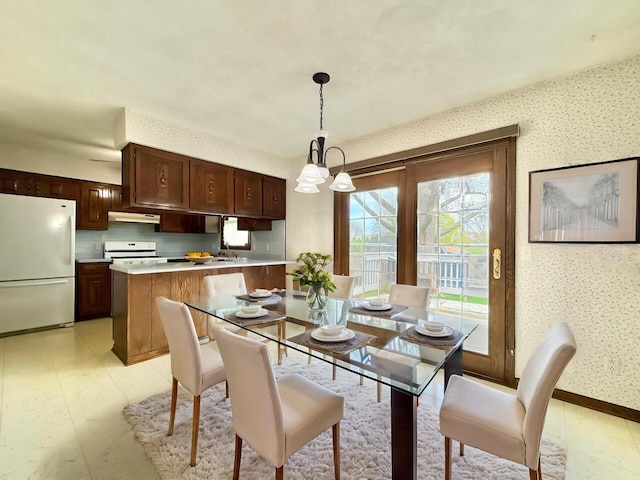 226 Westridge Rd, Janesville, WI 53548 - dining room featuring wallpapered walls, a notable chandelier, and baseboards