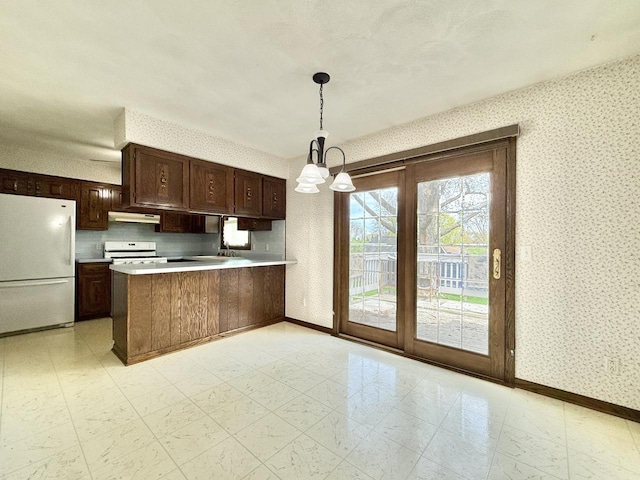 226 Westridge Rd, Janesville, WI 53548 - kitchen with an inviting chandelier, a peninsula, white appliances, wallpapered walls, and light countertops