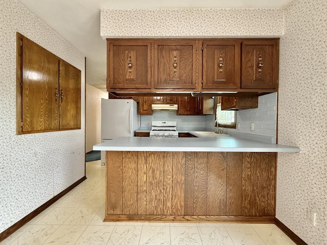 226 Westridge Rd, Janesville, WI 53548 - kitchen with a sink, a peninsula, under cabinet range hood, wallpapered walls, and white appliances