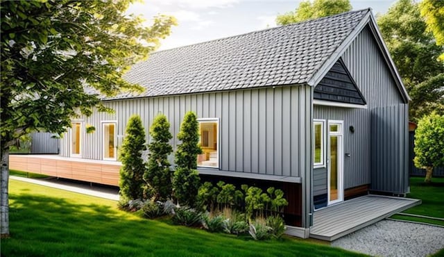 back of property with a lawn and roof with shingles