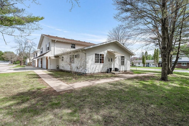 view of property exterior featuring a lawn and driveway