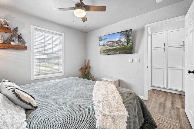 bedroom with baseboards, ceiling fan, and wood finished floors