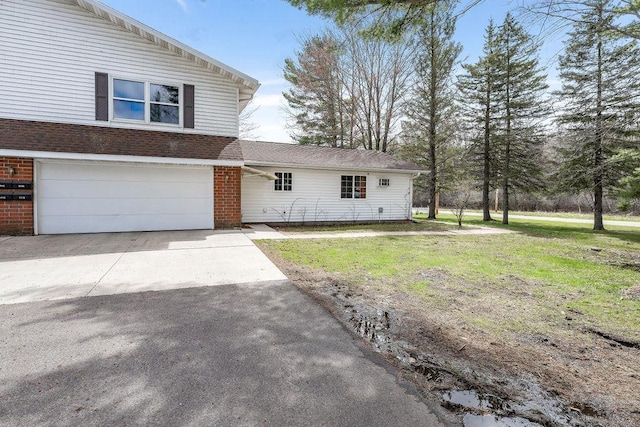 view of front of property featuring an attached garage, a front lawn, brick siding, and aphalt driveway
