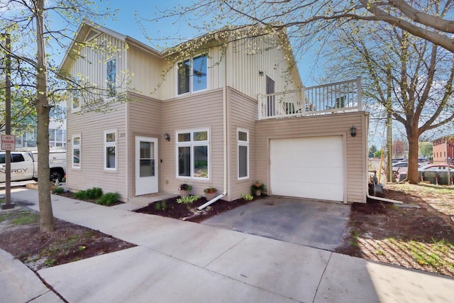 view of front of house with board and batten siding, an attached garage, driveway, and a balcony