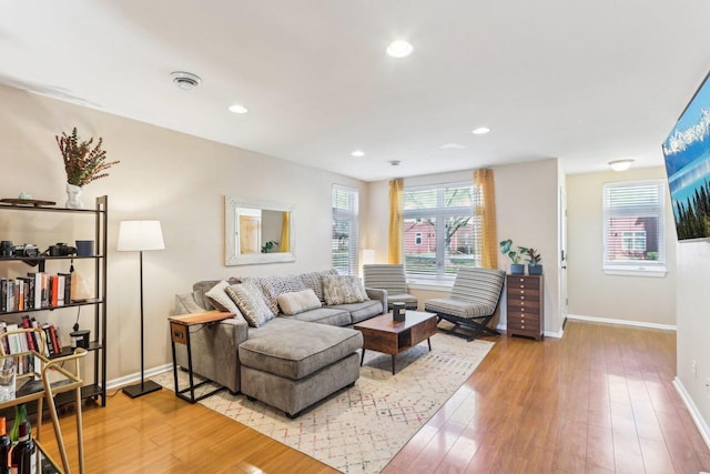 living room with baseboards, recessed lighting, and hardwood / wood-style floors