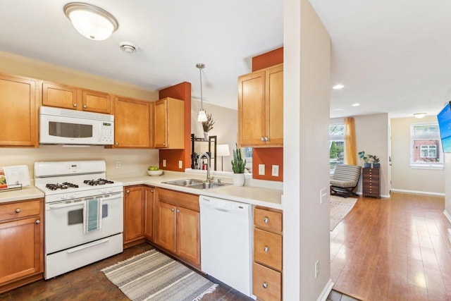 kitchen featuring a sink, white appliances, light countertops, decorative light fixtures, and baseboards