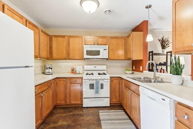 kitchen featuring a sink, light countertops, hanging light fixtures, and white appliances