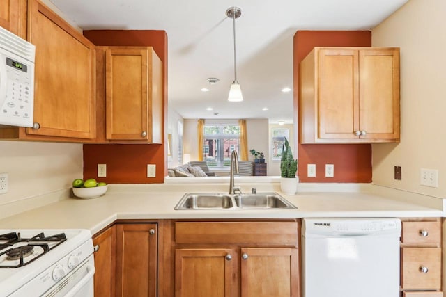 kitchen with a sink, white appliances, light countertops, recessed lighting, and decorative light fixtures