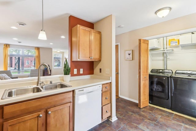 kitchen with pendant lighting, washing machine and dryer, dishwasher, a sink, and light countertops