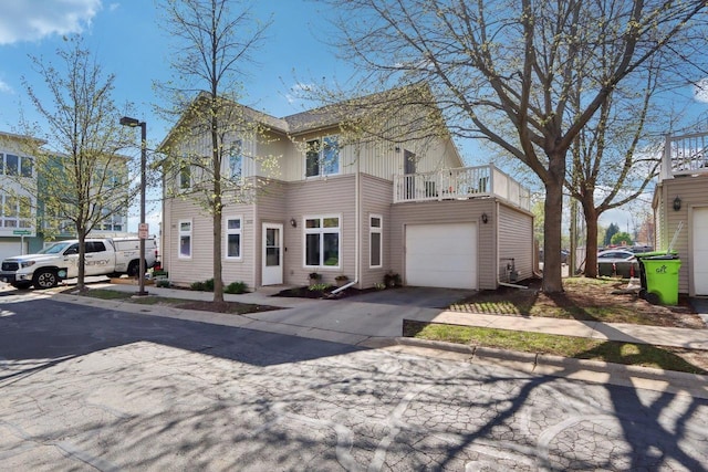 view of front of property with driveway, a balcony, and a garage