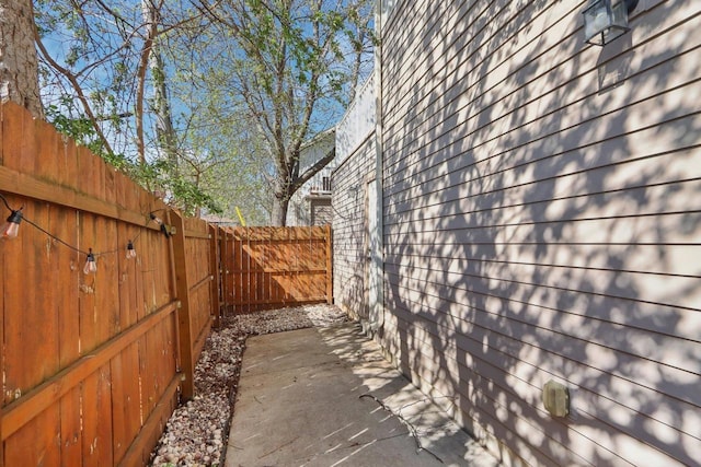 view of side of home featuring a fenced backyard and a patio area