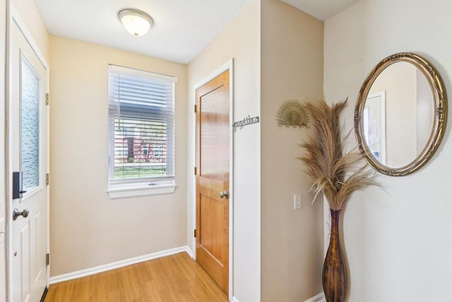 corridor with baseboards and light wood-style flooring