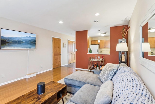 living area with recessed lighting, baseboards, and wood finished floors