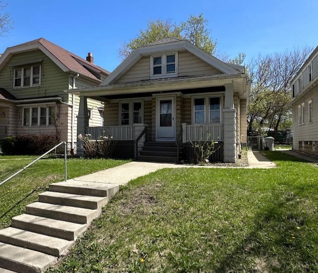 bungalow-style home with a front lawn and covered porch