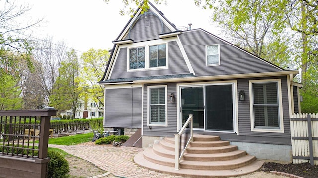 rear view of house featuring fence and entry steps