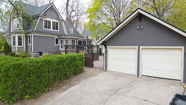 view of front of home featuring a detached garage, a shingled roof, and an outdoor structure